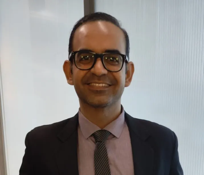 Narendra Jetley, smiling, in a dark suit and tie